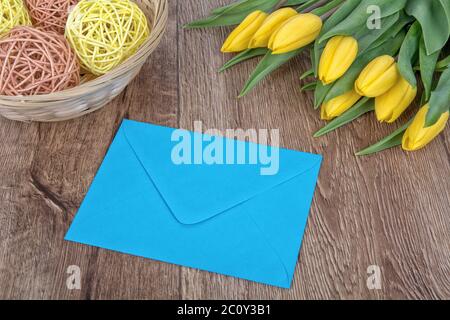 Envelope and tulips on a wooden background Stock Photo