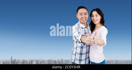 Composite image of happy couple showing thumbs up against white background Stock Photo