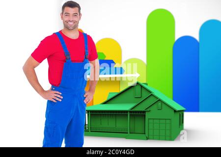 Composite image of happy handyman in overalls with hands on hip Stock Photo