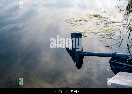 Boat docked with motor above water surface Stock Photo