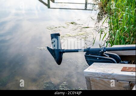 Boat docked with motor above water surface Stock Photo