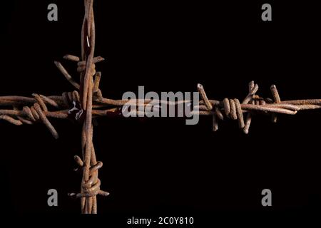 Rusty barb wire cross. Stock Photo