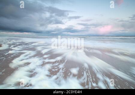 blurred sea waves at sunrise Stock Photo