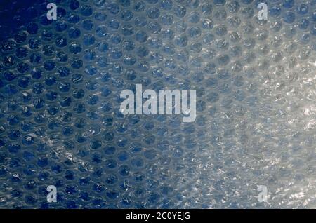 Air bubble wrap on blue. Creative multitask background for various tasks. Geometric symmetric shiny festive. The basis for various design tasks. Stock Photo