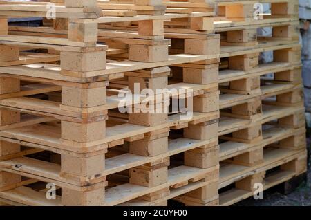 Empty wooden pallets outdoors. A stack of pallets for easy transportation and protection of various goods. Logistics and modern packaging. Selective f Stock Photo