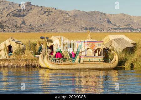 Family living on floating reed islands at Lake Titicaca Peru Bolivia Stock Photo