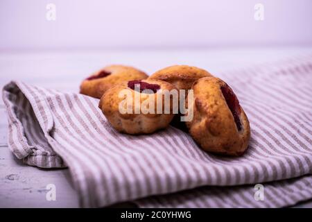 Homemade strawberry muffins on wooden tray with white checked napkin underneat. Stock Photo