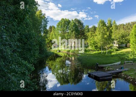 Small river Suonenjoki flowing through quiet residential area at Iisvesi Petsamo countryside at Summer , Finland Stock Photo