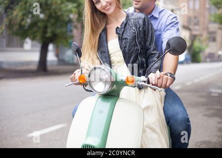 Happy young couple by a vintage scooter on the street Stock Photo