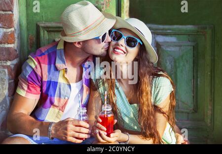 Happy young couple in the street wearing hats and sunglasses Stock Photo