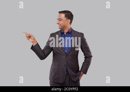 Businessman Pointing to Side Isolated. Indian Man Standing Stock Photo