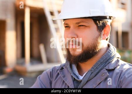 Close up portrait of construction manager and builder wearing hardhat. Stock Photo