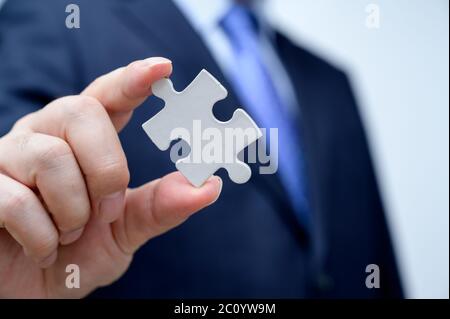 Businessman showing a jigsaw puzzle piece. Business and teamwork concept. Stock Photo