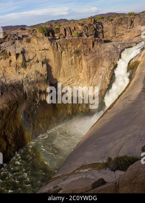 The Augrabies Waterfall in the afternoon, with a rainbow at the base were it plunge into the Orange River Gorge, Augrabies National Park, Northern Cap Stock Photo