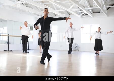 Mixed race dance teacher demonstrating ballroom dancing Stock Photo