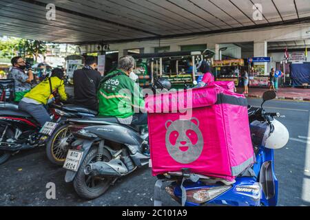 BANGKOK, THAILAND - APRIL 2020 : Various food delivery box on the motorcycles include Food Panda, Grab and Get food at Food delivery service point on Stock Photo