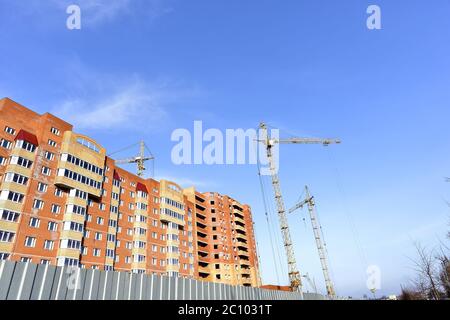 Crane and building construction site against blue sky Stock Photo