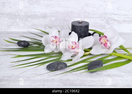 arrangement on white table with orchid, pebbles and candle Stock Photo