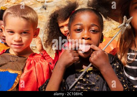 Portrait of the little girl stick out tongue making fun and gesticulating in Halloween costumes Stock Photo