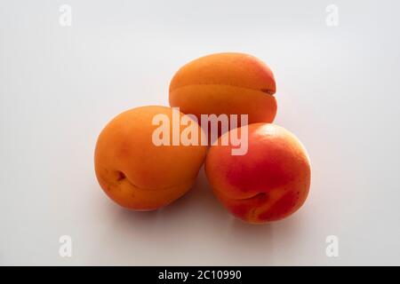 Close-up of three raw apricots Stock Photo