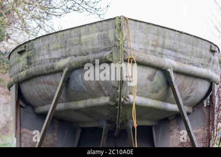 Old metal boat in dry dock for repair. Close up of the bow of an old tin or galvanised metal boat. Stock Photo