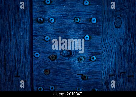 The texture of dark blue wood with old screws. Texture of old dried plywood. Classic blue background for design. Stock Photo