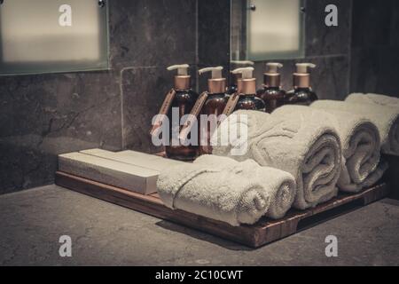 Stack of towels  in the bathroom with liquid soap dispenser  and tooth brushes  closeup Stock Photo