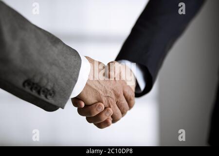 Business people in office suits standing and shaking hands, close-up. Business communication concept. Handshake and marketing Stock Photo