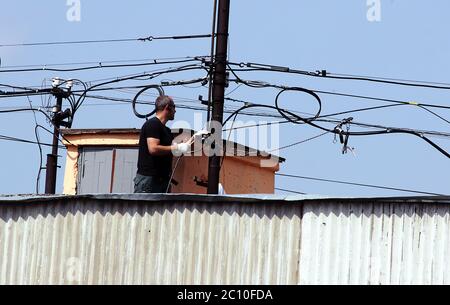 technicain stand on a roof to connect fiber-optic cables. Stock Photo