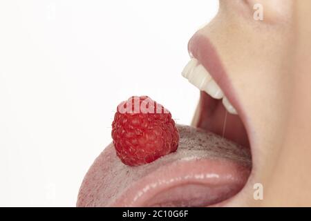 Raspberry on the tongue Stock Photo - Alamy
