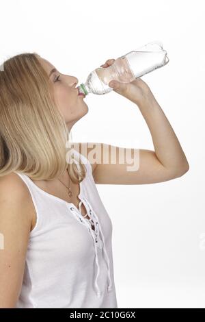 Young blonde woman drinks mineral water from the bottle Stock Photo
