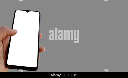 Asian male holding smartphone in hand and touching screen and watching mobile isolated image Stock Photo