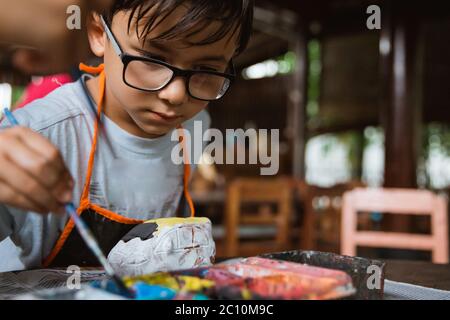 Caucasian boys paint colored crafts in pottery galleries with class friends Stock Photo
