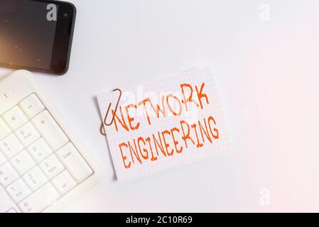 Handwriting text Network Engineering. Conceptual photo professional who has the skills to oversee the net White pc keyboard with empty note paper abov Stock Photo