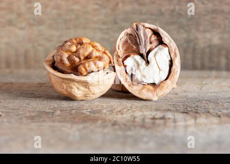 Close-up tasty healthy chopped and unshelled walnuts on a wooden old table. Vegetarian food Stock Photo