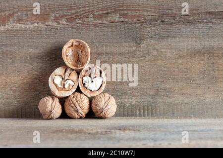 Close-up tasty healthy chopped and unshelled walnuts on a wooden old table. Vegetarian food Stock Photo