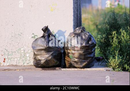 two bags of garbage near the bus stop Stock Photo