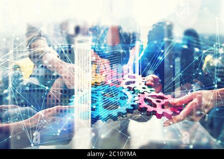 Working group of businessmen find the agreement by holding a piece of gear in hand. concept of teamwork and business partnership. double exposure with Stock Photo