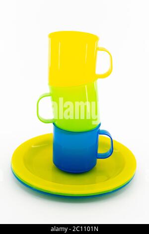The three colored mugs and three colored saucers on a white background Stock Photo