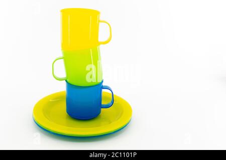 The three colored mugs and three colored saucers on a white background Stock Photo