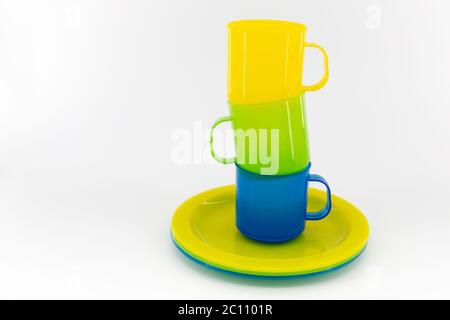 The three colored mugs and three colored saucers on a white background Stock Photo
