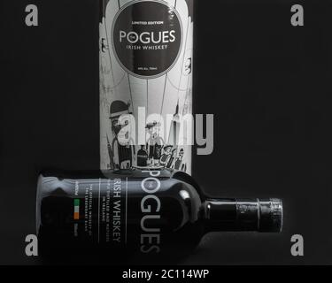 KIEV, UKRAINE - MAY 15, 2019: The Pogues blended Irish Whiskey triple distilled and matured bottle and box closeup against black background. It is the Stock Photo