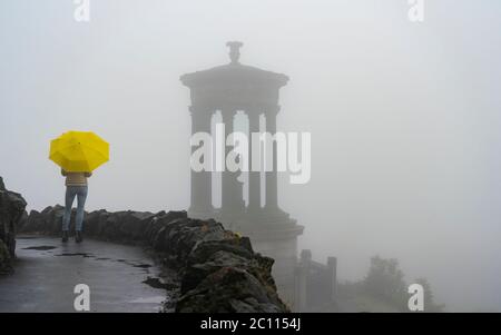 Edinburgh, Scotland, UK. 13 June 2020. A thick fog ,or haar as it is called locally, covers the city and obscures the famous tourist viewpoint from Calton Hill. Normally the viewpoint is busy with tourists , however, with the fog and Covid-19 lockdown continuing, only a few members of the public ventured up the hill today. The Dugald Stewart Monument is visible but not the famous Edinburgh skyline.  Iain Masterton/Alamy Live News Stock Photo