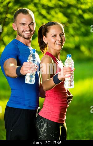 Man and woman drinking water from bottle after fitness sport exercise Stock Photo