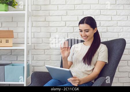 Young smiling hispanic woman using tablet greeting friend in video call, social connection Stock Photo