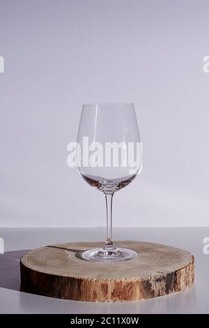 Glass of wine on white background, high key, wooden stump Stock Photo