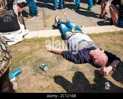 London, UK. 13th June, 2020. A protestor is passed on the grass in Parliament Square. Counter-protesters consisting of nationalist supporters members of the English Defence League (EDL) and fans of Tommy Robinson gather to protest about the damage done to statues, such as Winston Churchills, and the subsequent removal of statues triggered by damage done during the Black Lives Matter Protests in London, UK. Credit: Yousef Al Nasser/ Alamy Live News Stock Photo