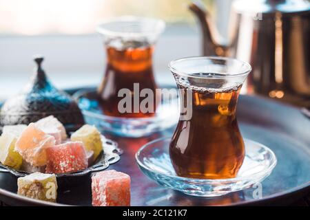 Glass Cup of turkish tea served in traditional style with summer outdore view Stock Photo