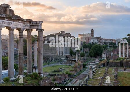 Perspective of the Roman Forum ancient ruins and Colosseum ampitheater, in Rome, Italy, with temple of Saturn, temple of Vesta, Basilica of Maxentius, Stock Photo