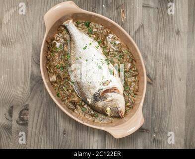 Fish cooked bream baked with stewed artichokes Stock Photo